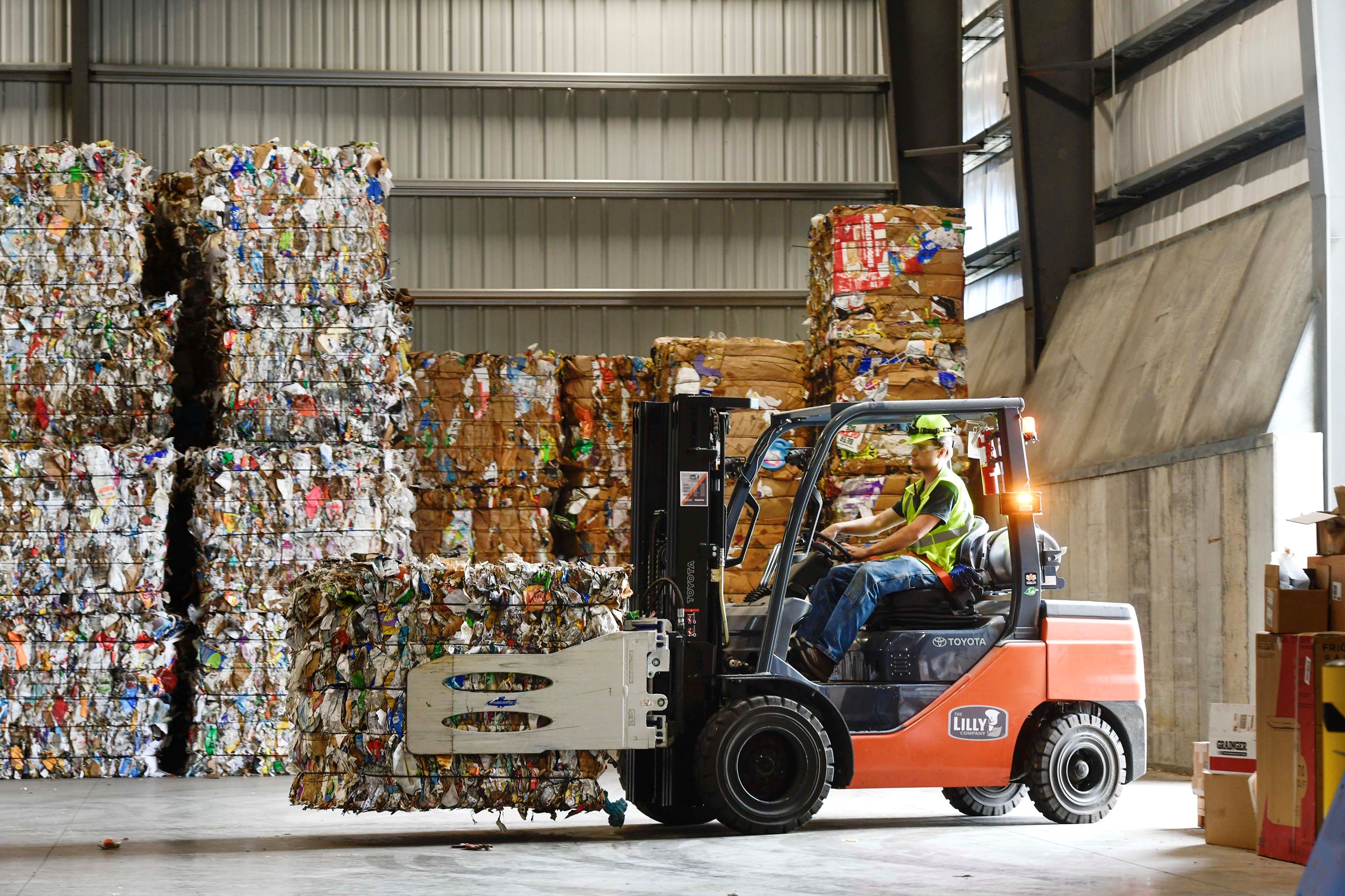A worker uses a forklift to move recycled material at WM's new facility in Fort Walton Beach.